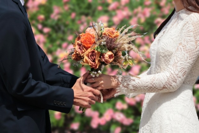 花束を渡すカップルの首から下