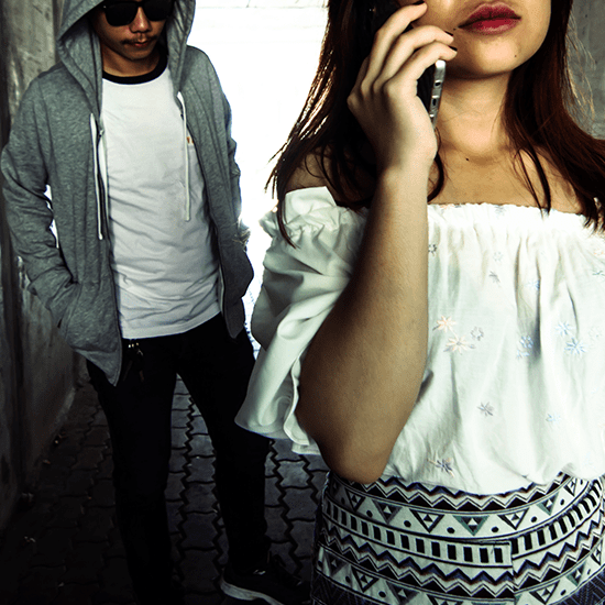 後ろに怪しい男が映る女性